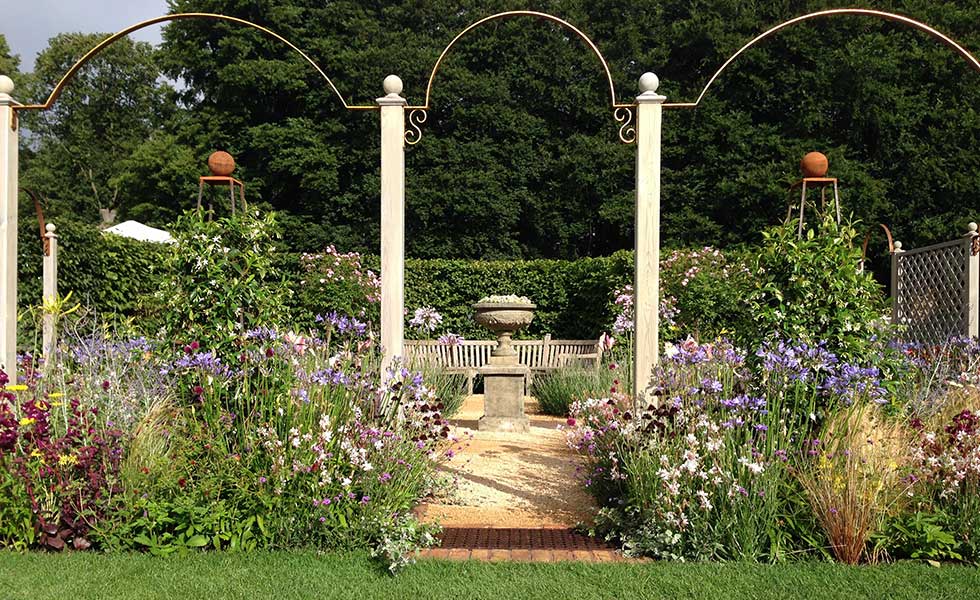traditional english country garden with pedestal and arches