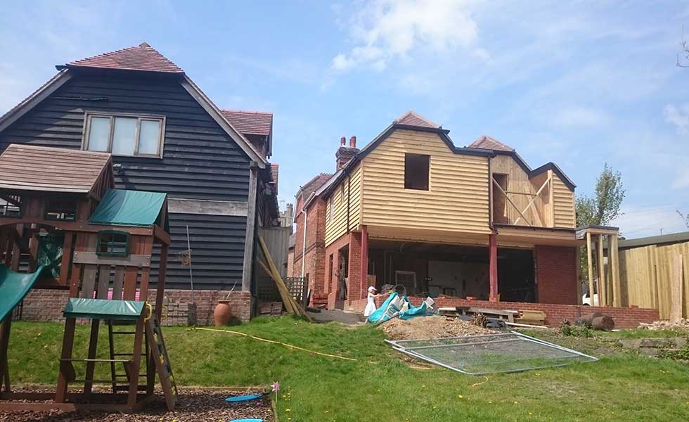 an extended Victorian home with red cedar cladding and hipped roof
