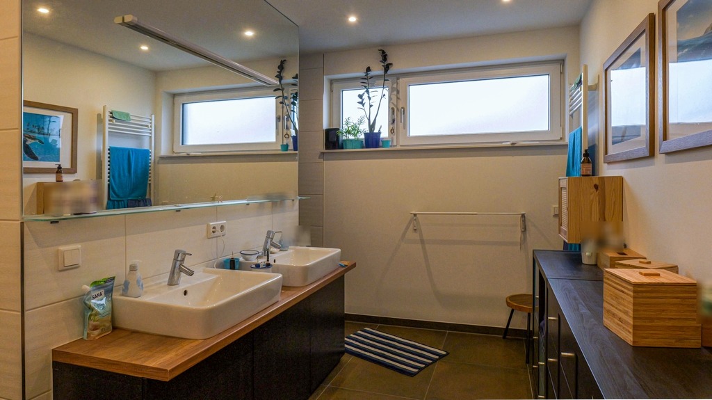 Badezimmer mit Dusche, Wanne, Handtuchheizung und zwei Waschbecken