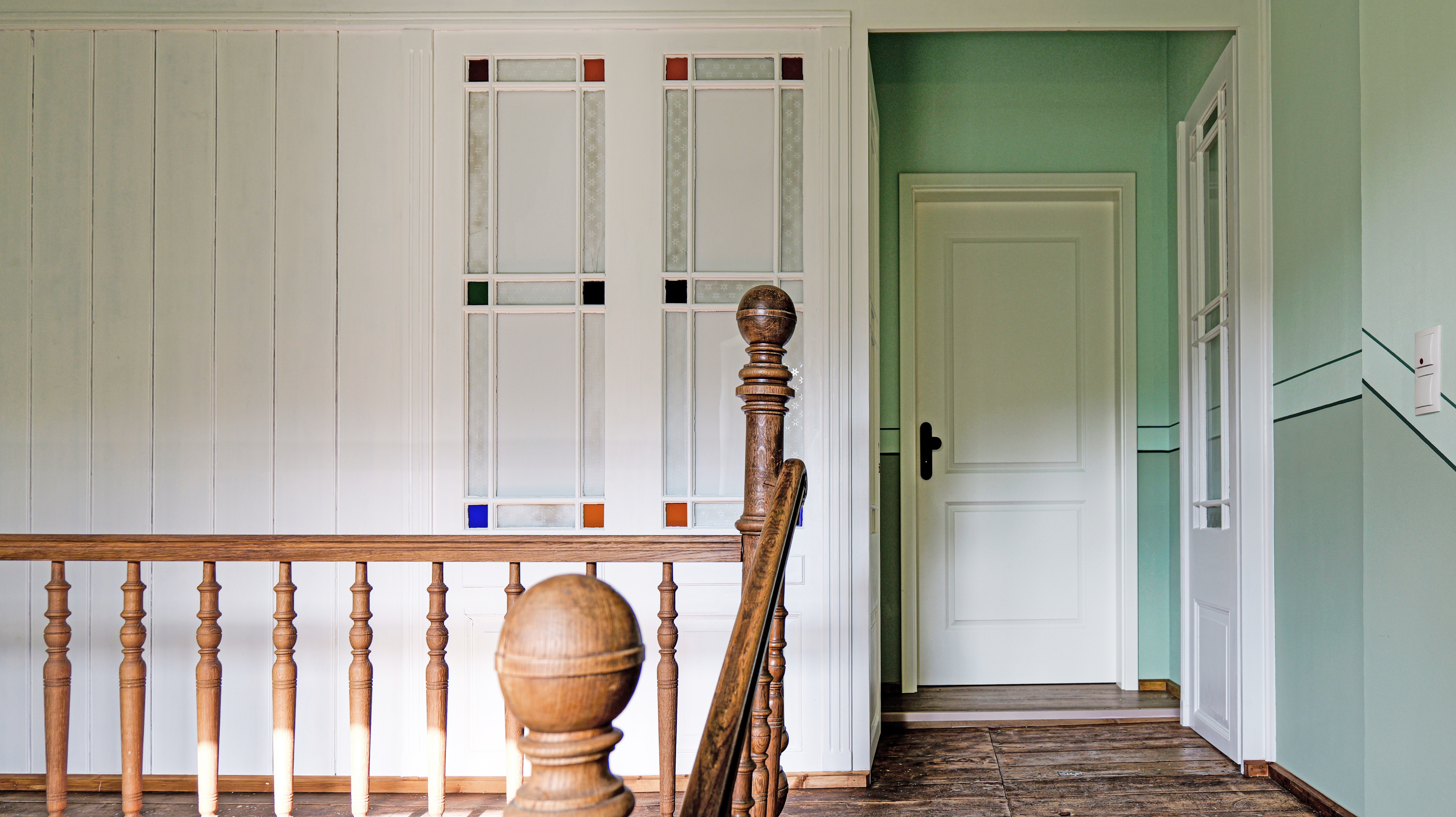 Historischer Charme, der begeistert – kunstvoll gearbeitete Holzvertäfelung mit Glaseinsätzen verleiht dem Wohnungseingang einzigartige Eleganz.