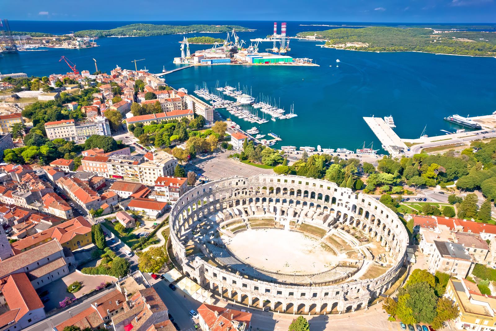Arena Pula. Ancient ruins of Roman amphitheatre and Pula waterfront aerial view, Istria region of Croatia