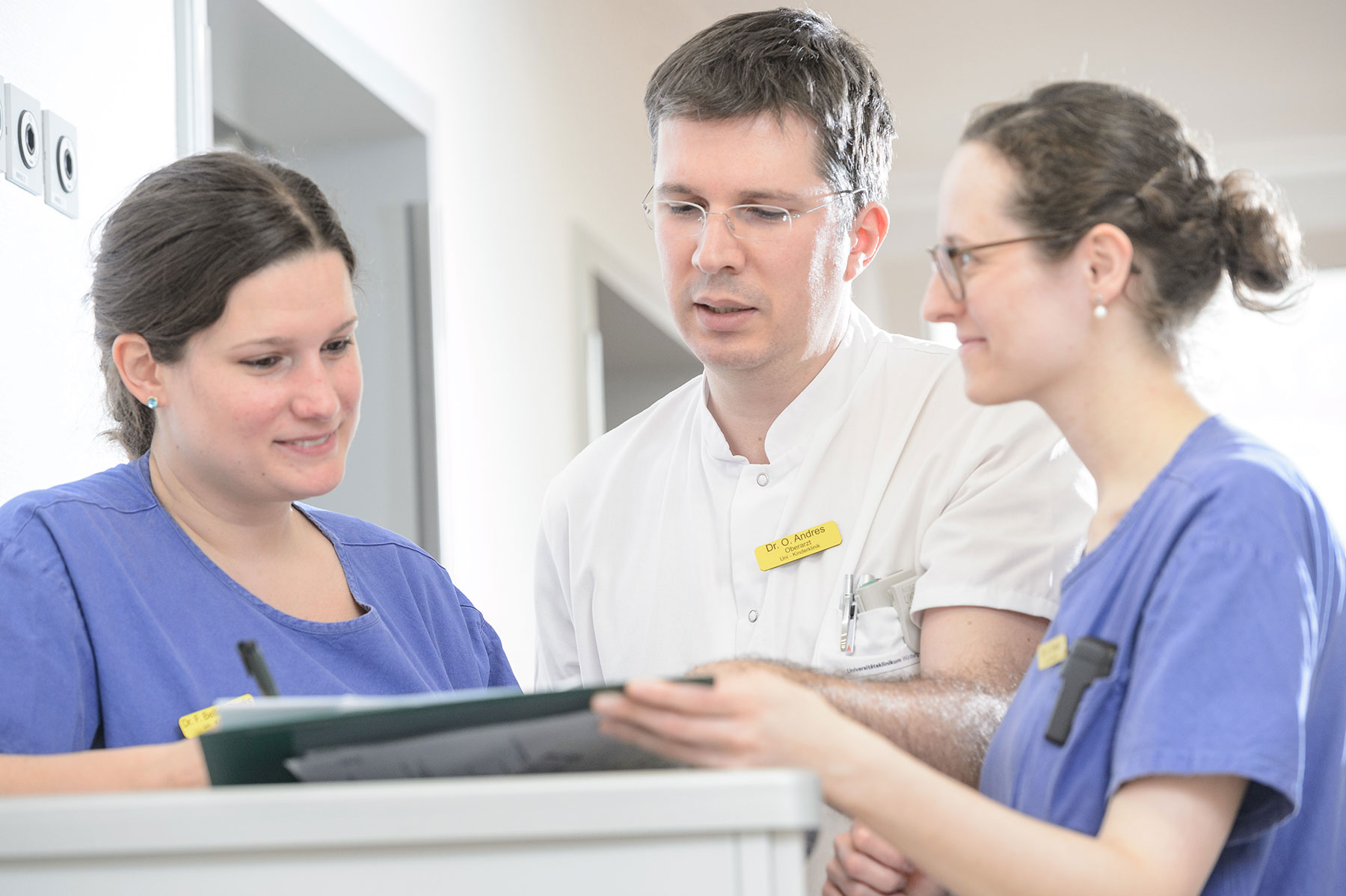 Medizinisches Team der Kinderklinik des Uniklinikums Würzburg bei der gemeinsamen Visitenplanung auf dem Flur.