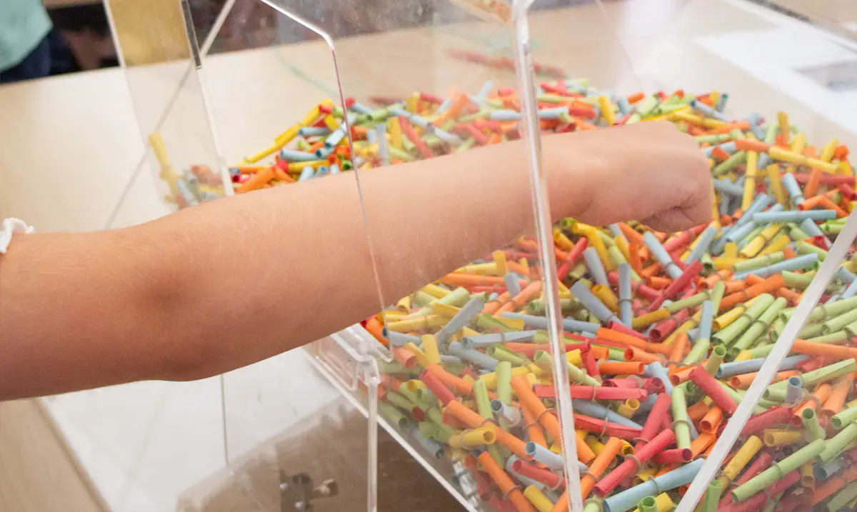 Eine Hand greift in einen Behälter voller Lose