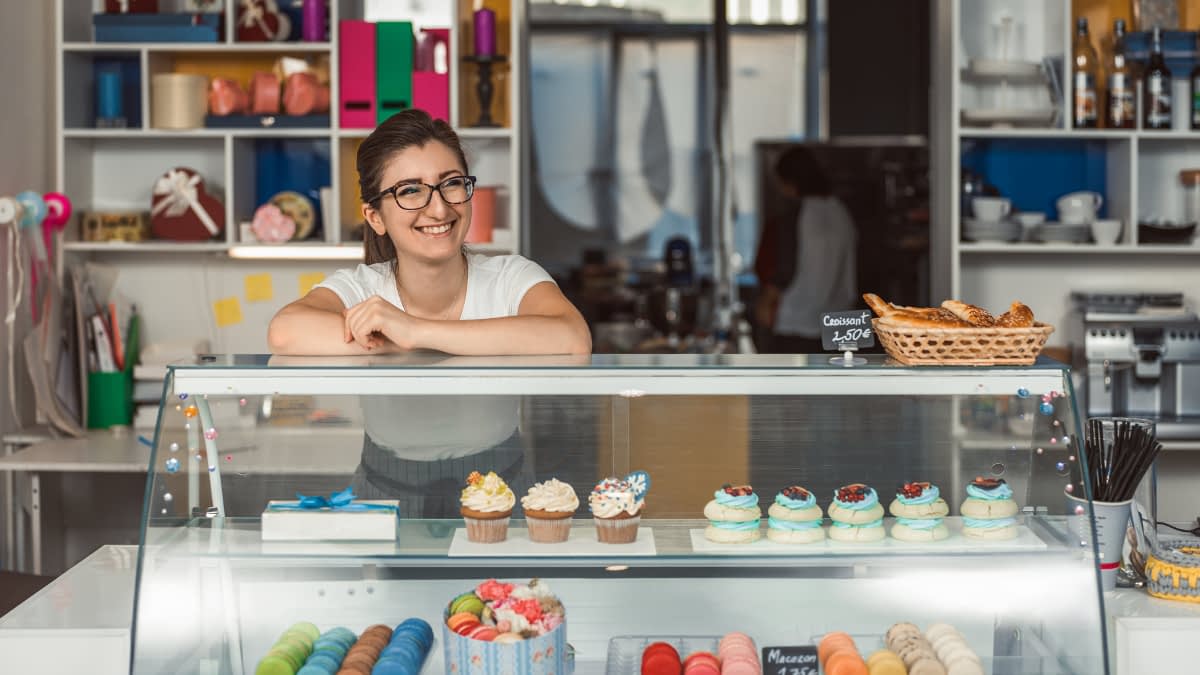 Frau steht hinter Verkaufsthresen Frau steht hinter Verkaufsthresen