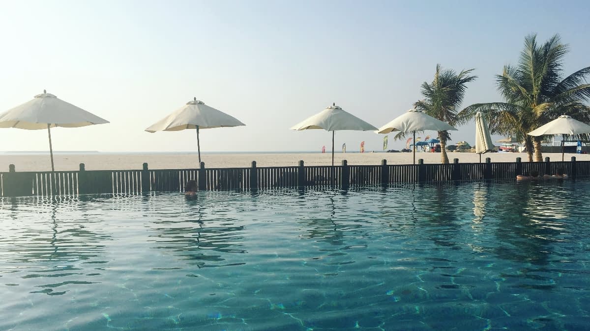 Sonnenschirme, Palmen und Wasser