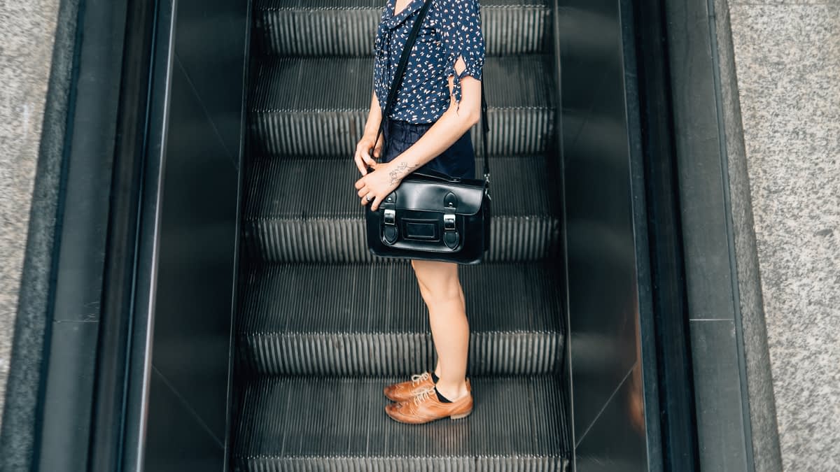 Frau auf Rolltreppe Frau auf Rolltreppe