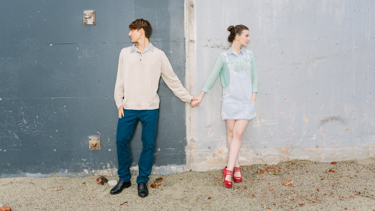 Händchenhaltendes Pärchen blickt in zwei verschiedene Richtungen