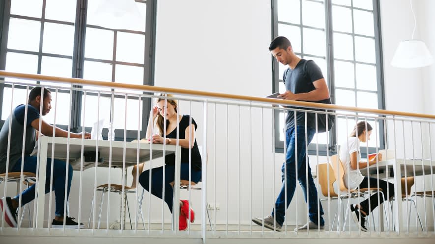 Frauen sitzen an Tisch und Mann geht