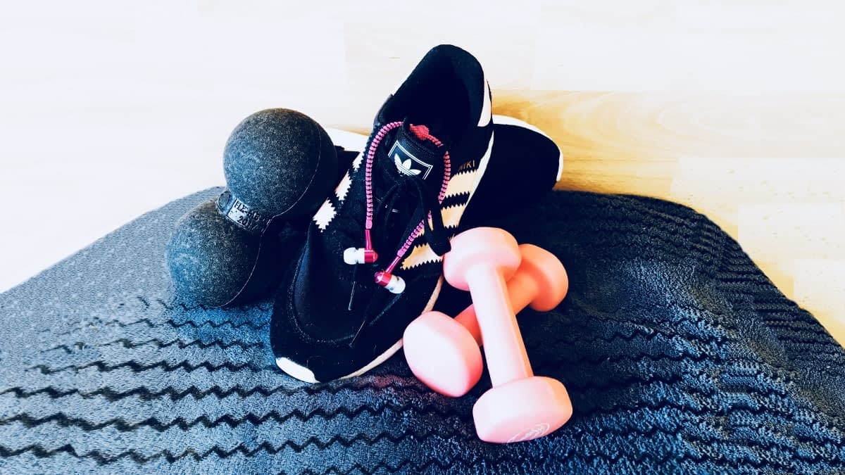 Sportschuhe und pinke Hanteln