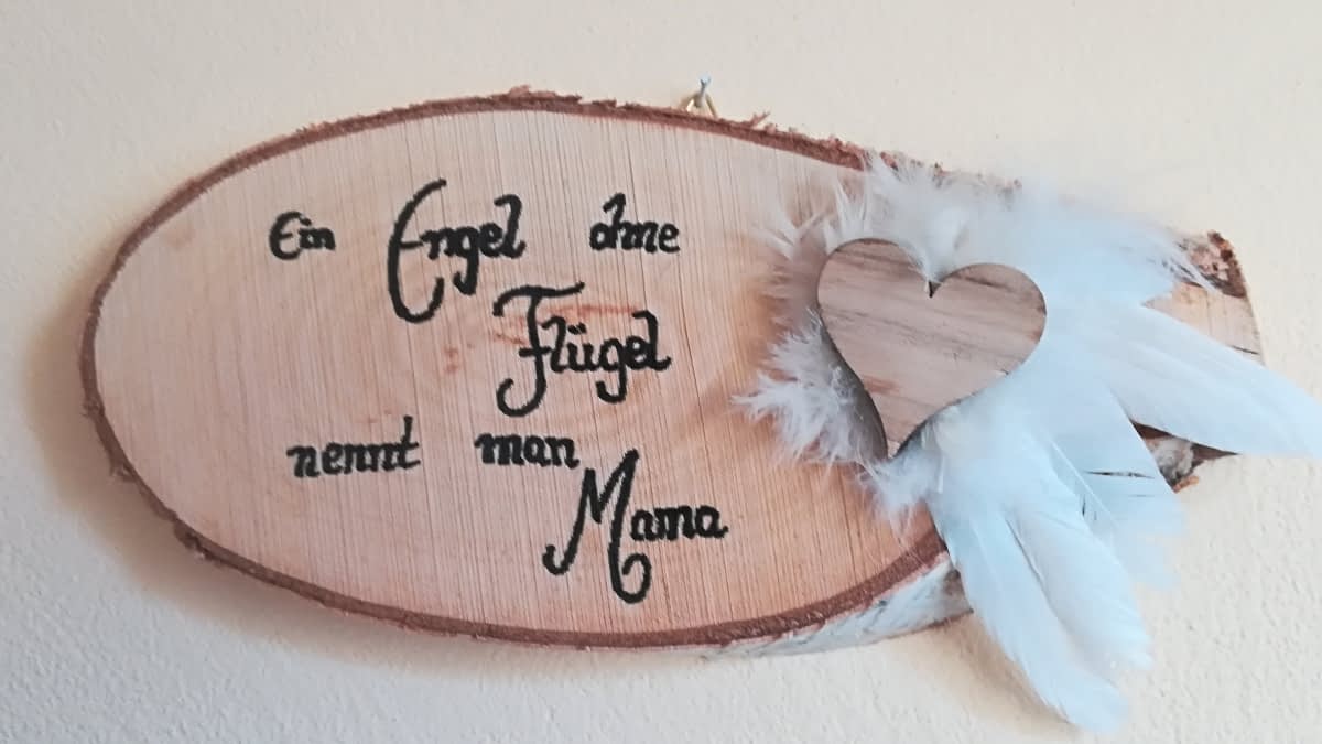 Holzbrett mit Aufdruck und Federn