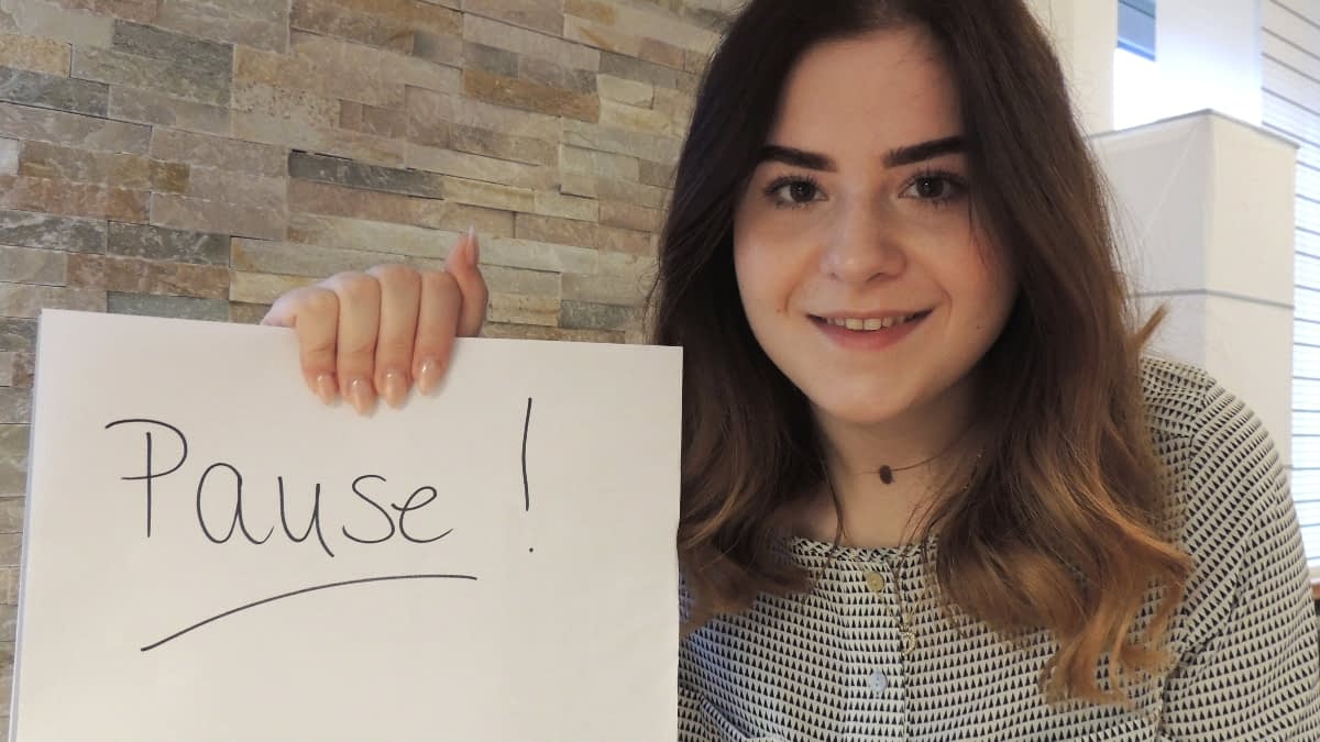 MS-Betroffene Lara mit Pause-Schild