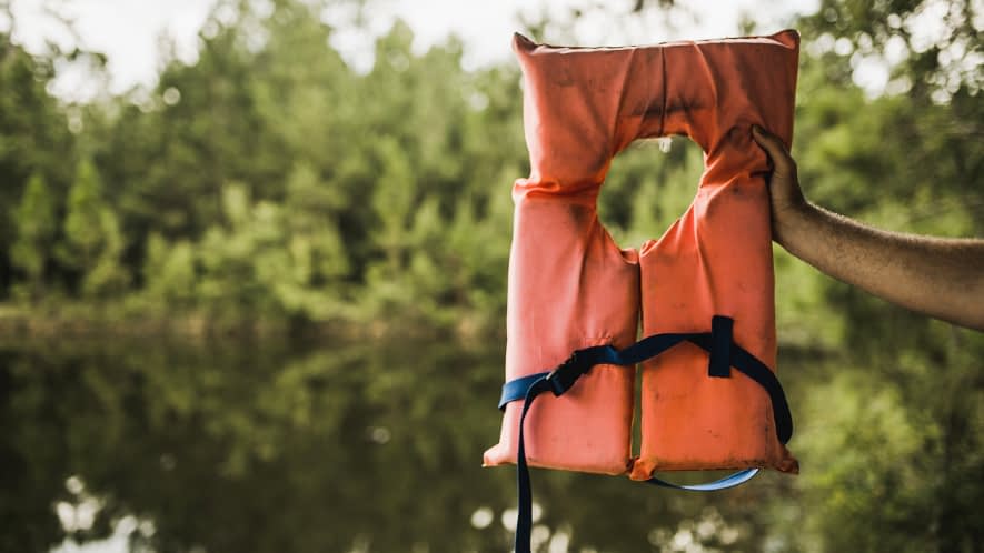 Hand hält Schwimmweste 