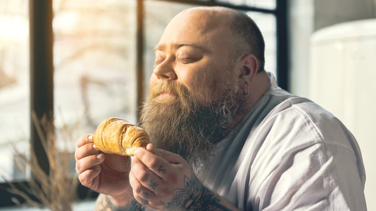 Mann riecht an Croissant