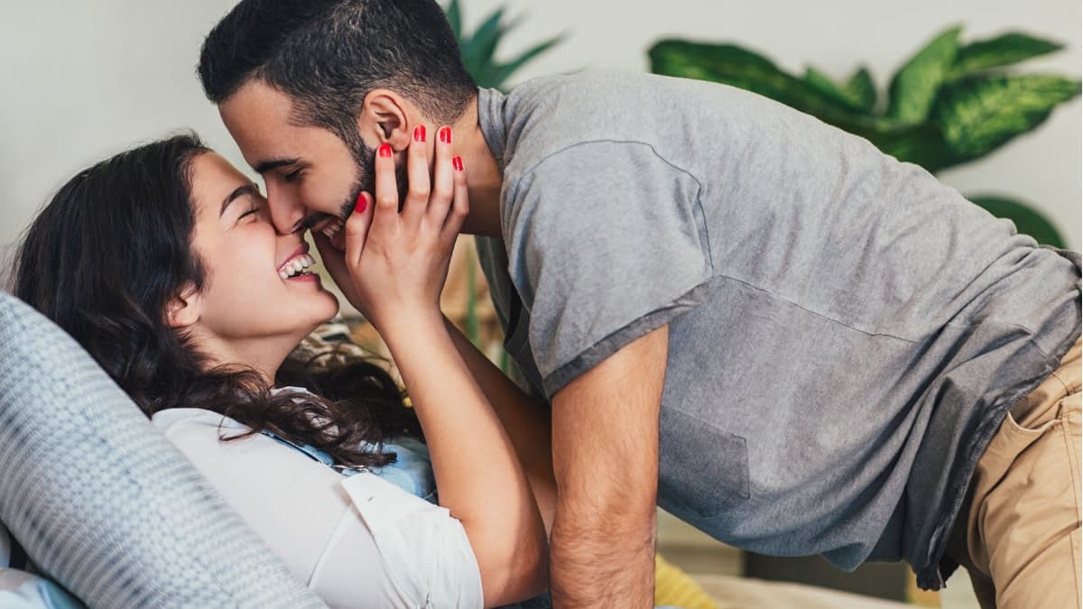 Frau hält Kopf von einem Mann mit beiden Händen nah an ihrem Gesicht