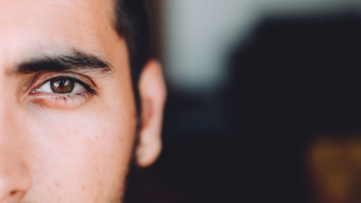 Auge eines Mannes mit schwarzen Haaren Auge eines Mannes mit schwarzen Haaren