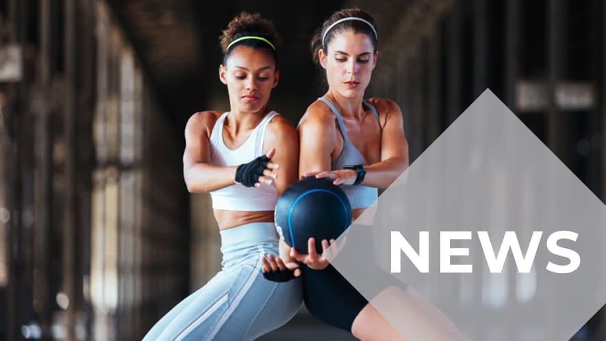 Zwei Frauen stehen Rücken an Rücken und reichen sich einen Ball