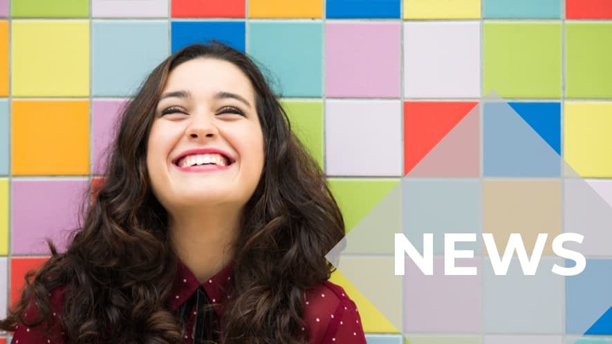 Lachende Frau vor bunter Wand