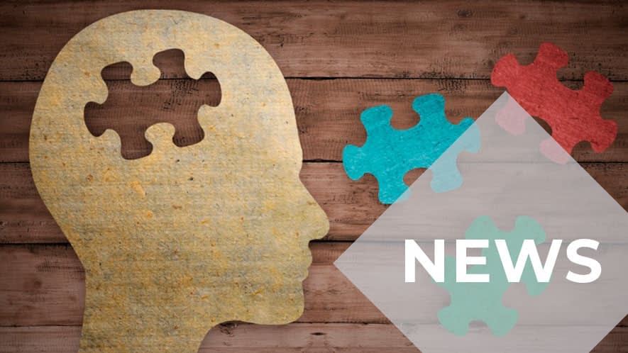 Kopfprofil aus Papier auf Holzuntergrund mit Puzzleteilen