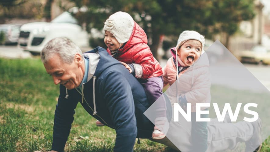 Älterer Herr macht Liegestütz mit Enkelkindern auf dem Rücken