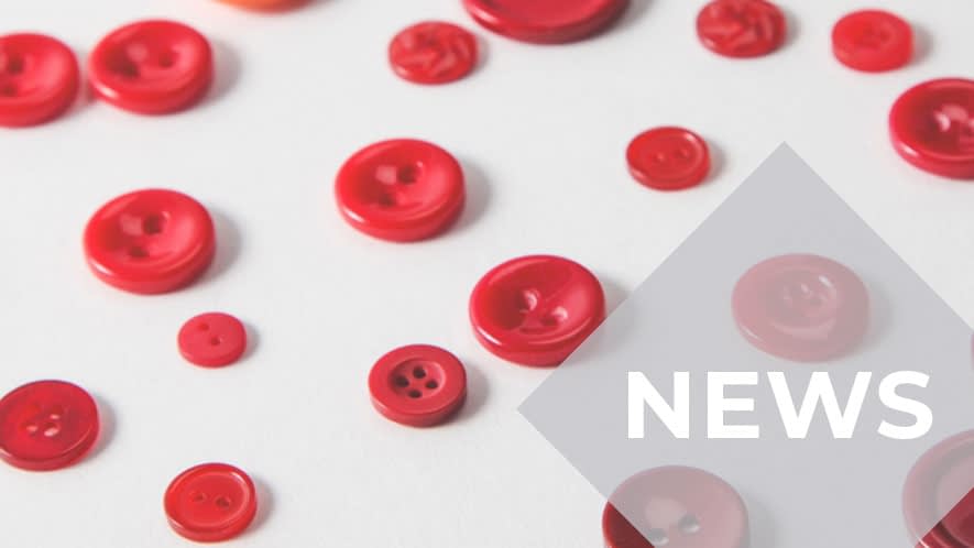 Kleine und große rote Knöpfe wahllos verteilt auf grauem Untergrund