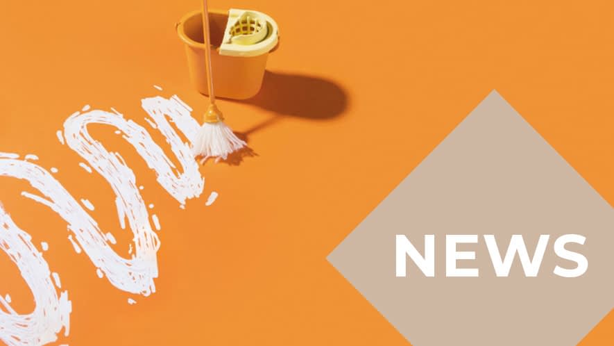 Eimer und Wischmob mit weißer geschlängelter Farblinie auf orangefarbenem Untergrund