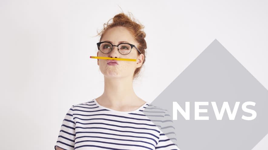 Frau mit Brille und gestreiftem Shirt balanciert Bleistift auf Oberlippe