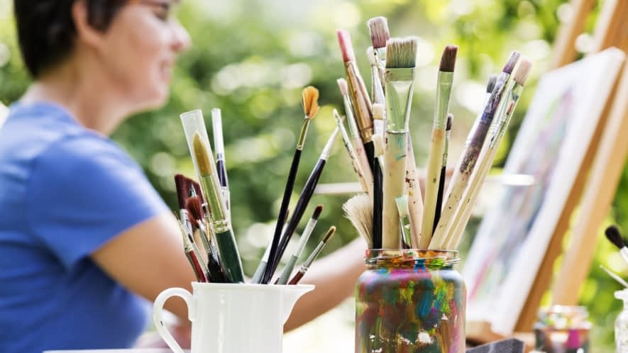 Frau malt ein Bild im Garten