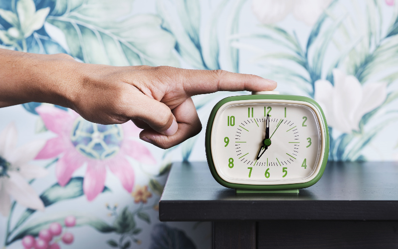 Mann stellt grünen Wecker aus