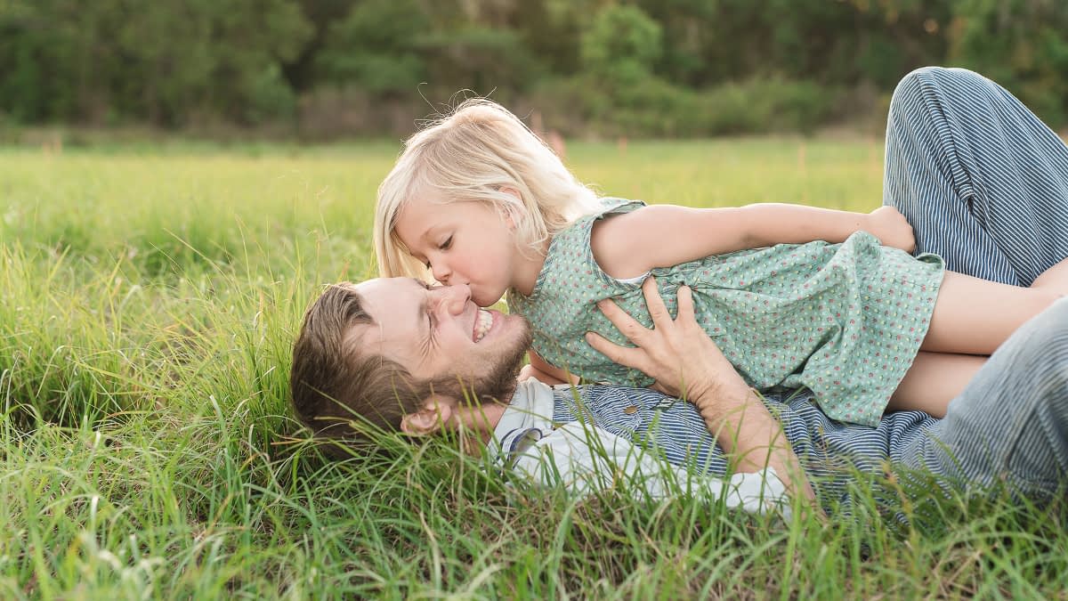 Kind liegt mit Vater auf einer Wiese Kind liegt mit Vater auf einer Wiese