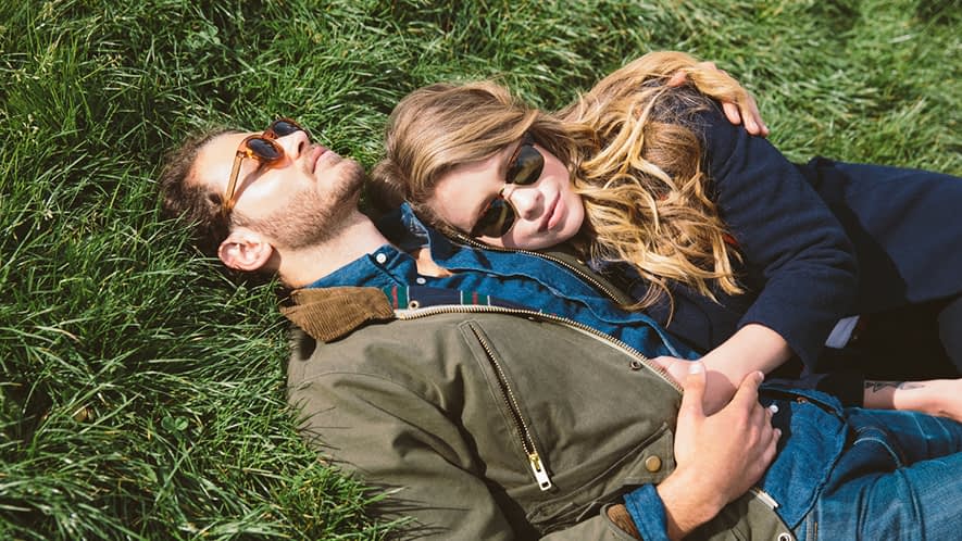 Ein Paar liegt kuschelnd auf einer Wiese