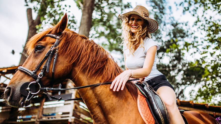 Frau mit MS reitet auf einem Pferd