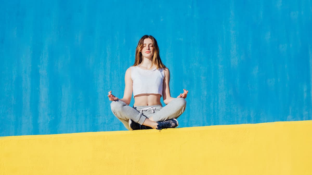 Frau macht Yoga auf einer Mauer