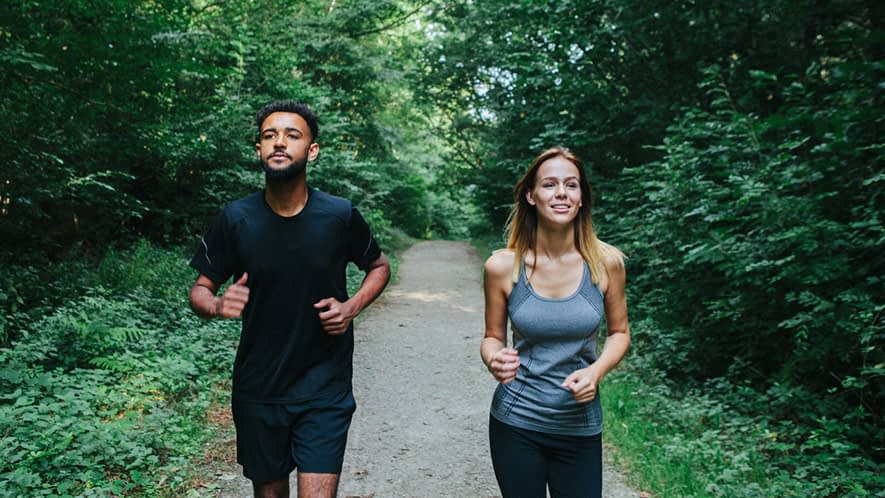 Mann und Frau joggen im Wald