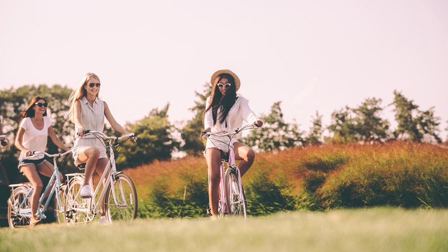 Drei junge Frauen fahren Rad