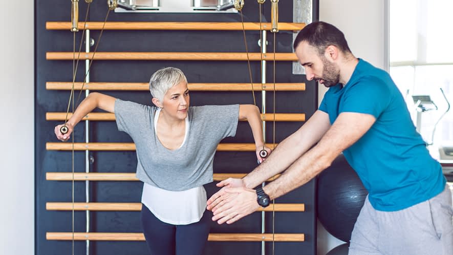 Ältere Frau macht Übungen in einem Fitness-Studio