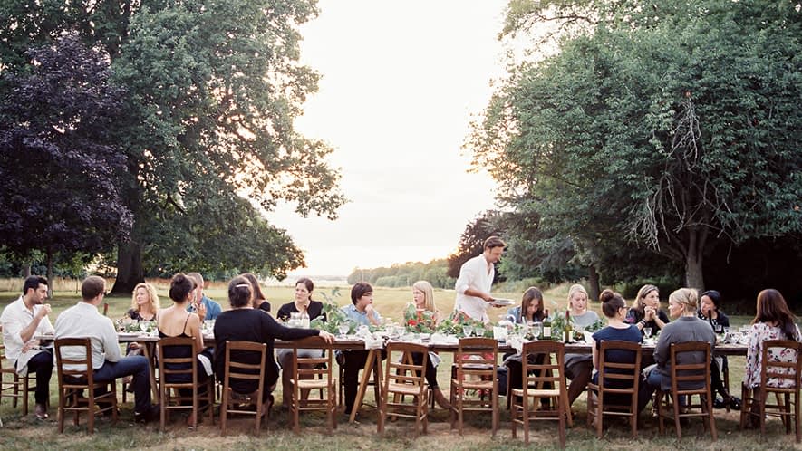 Viele Personen an einer großen Tafel im Freien