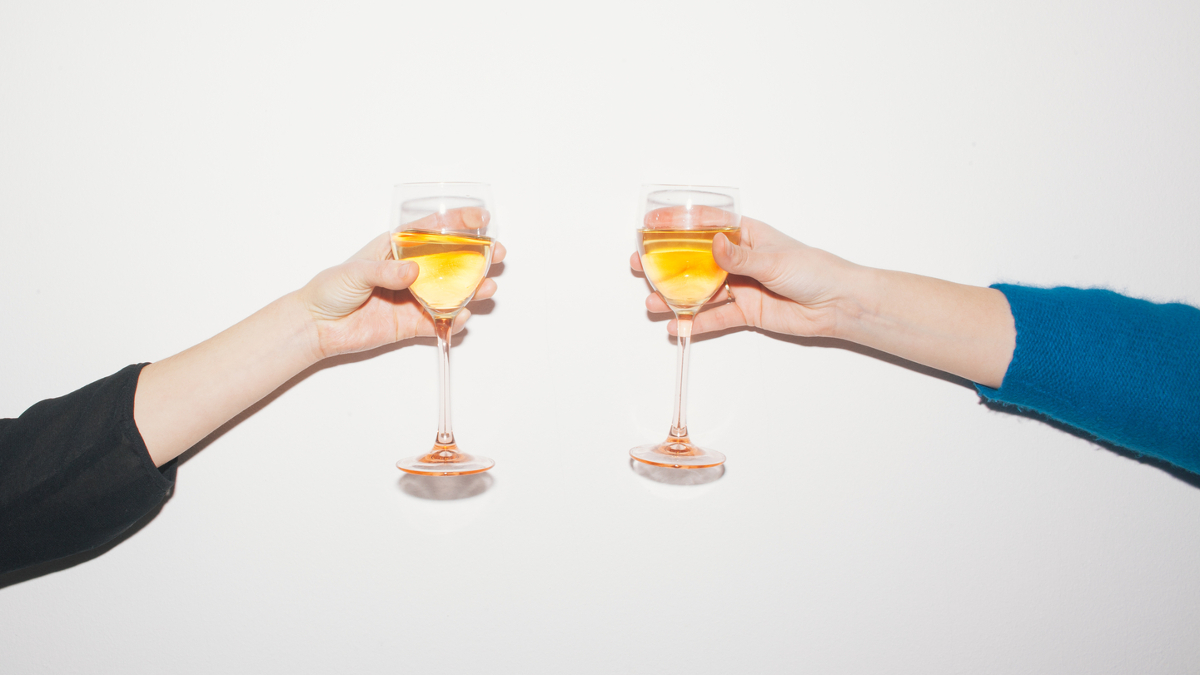 Zwei Personen prosten sich mit einem Glas Sekt zu