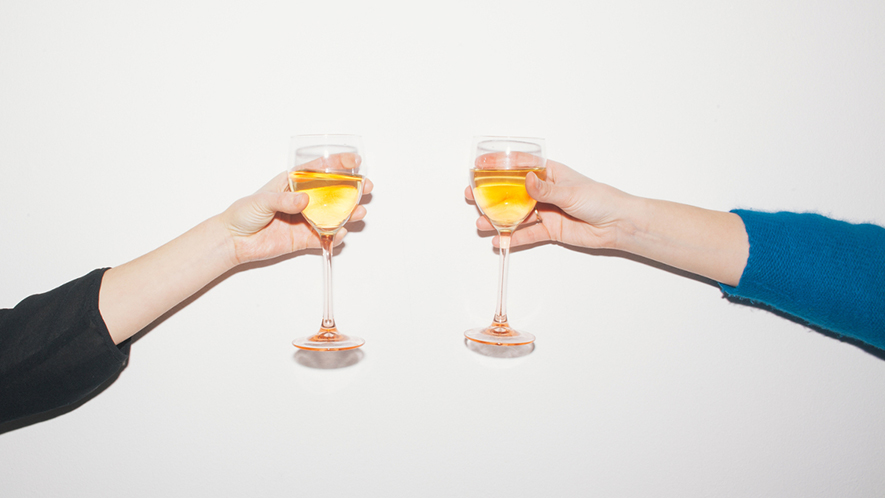 Zwei Personen prosten sich mit einem Glas Sekt zu