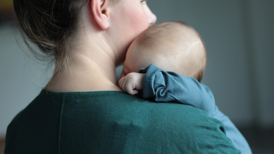 Frau hält Baby auf dem Arm. 