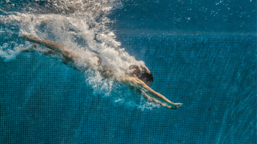 Frau springt kopfüber in einen Pool