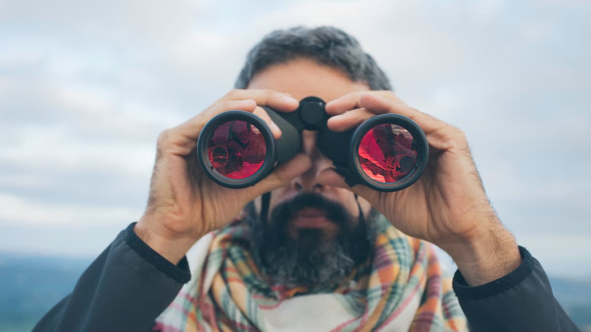Mann schaut durch ein Fernglas Mann schaut durch ein Fernglas