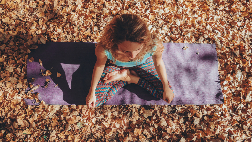 Frau auf Sportmatte im Wald