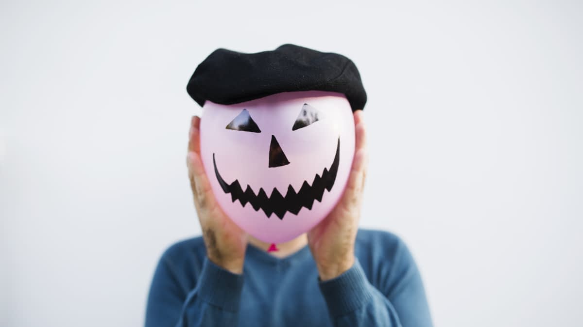 Mann mit Luftballon vor dem Gesicht