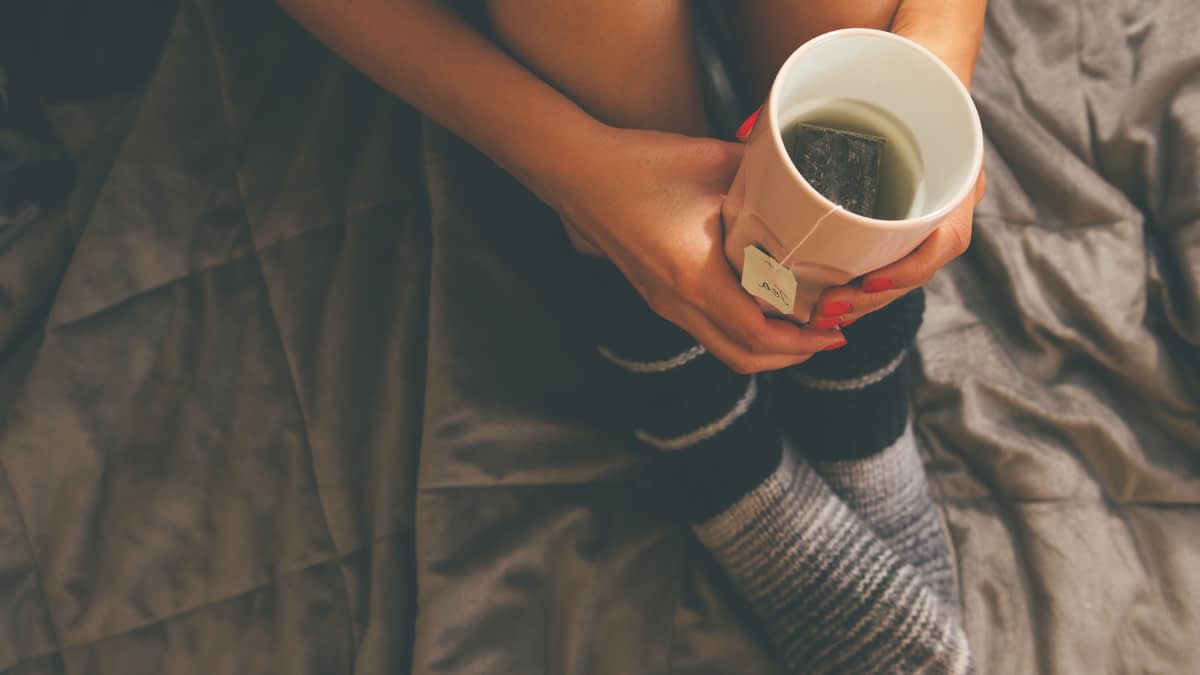 Ausschnitt von Frau mit Teetasse in der Hand