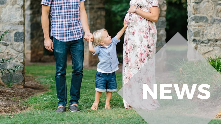 Kleines Kind an den Händen seiner Eltern