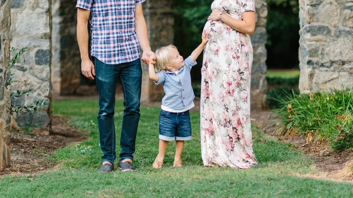 Kleines Kind an den Händen seiner Eltern