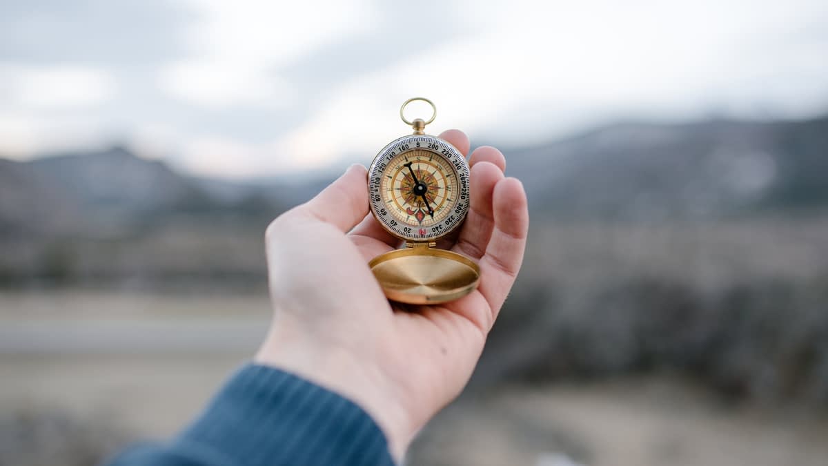 Hand, die einen Kompass hält Hand, die einen Kompass hält