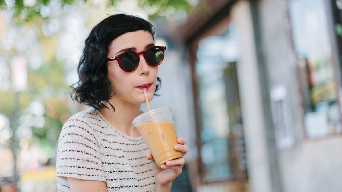 Frau mit Sonnenbrille und einem Getränk