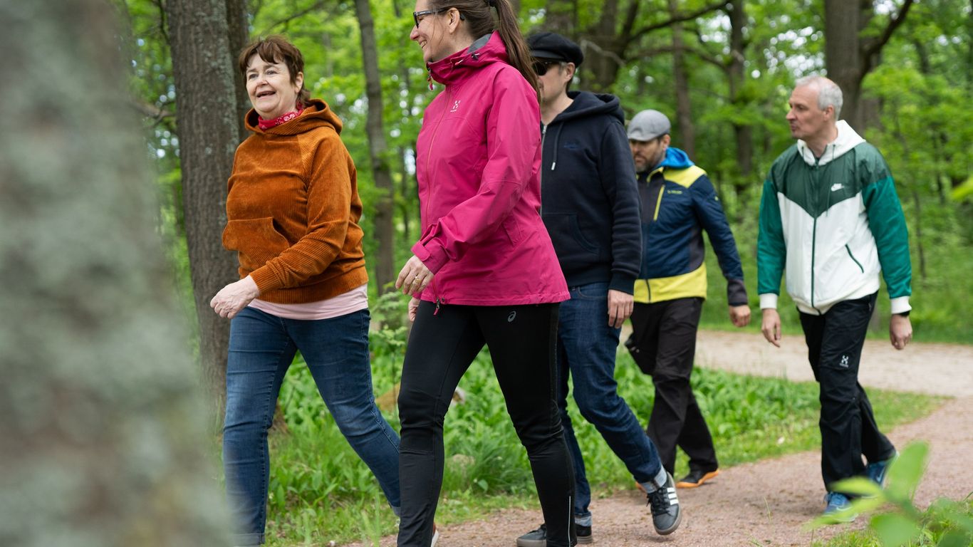 Kaksi naista ja kolme miestä kävelevät ryhmässä me