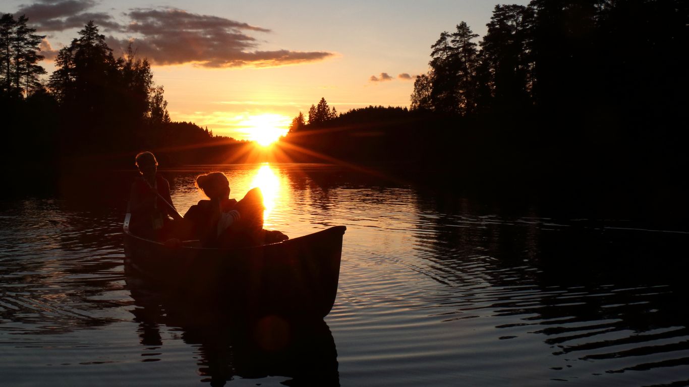 Auringonlasku ja kanootti melojineen